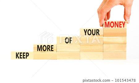 Keep more of your money symbol. Concept words Keep more of your money on wooden block. Beautiful white table white background. Businessman hand. Business keep more of your money concept. Copy space. 101543478