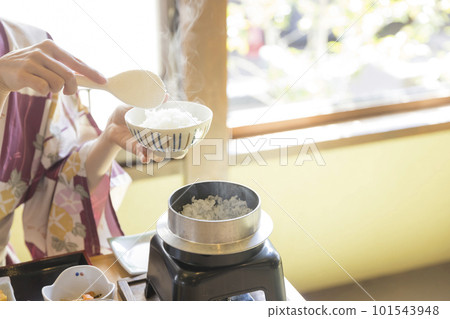 Image of breakfast at a ryokan A woman serving rice cooked in a pot Image of breakfast at a ryokan A woman serving rice cooked in a pot 101543948