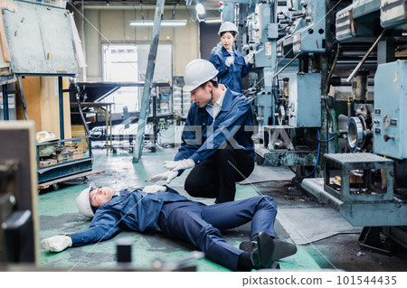 A staff member dealing with a work accident at a factory A staff member dealing with a work accident at a factory 101544435
