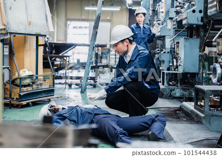 A staff member dealing with a work accident at a factory A staff member dealing with a work accident at a factory 101544438