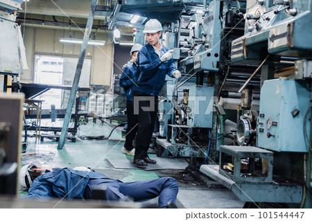 A staff member dealing with a work accident at a factory A staff member dealing with a work accident at a factory 101544447