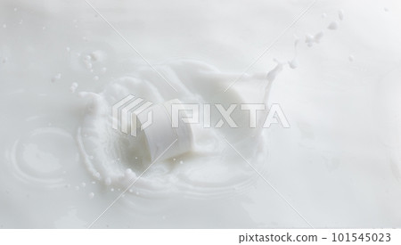 Cosmetic container white lotion droplet fly splashing. Milk lotion pour float to cosmetic bottle. Moisturizer lotion explosion spill. White background isolated high speed shutter freeze top view 101545023