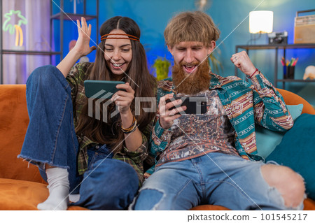 Happy family married couple man woman playing shooter video app games online on smartphone at home Happy family married couple man woman playing shooter video app games online on smartphone at home 101545217