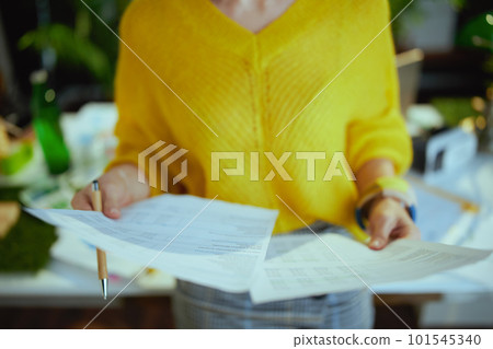 Business owner woman in green office working with documents Business owner woman in green office working with documents 101545340