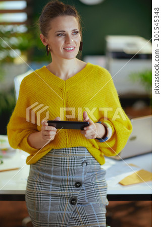 smiling trendy business owner woman in green office using phone smiling trendy business owner woman in green office using phone 101545348