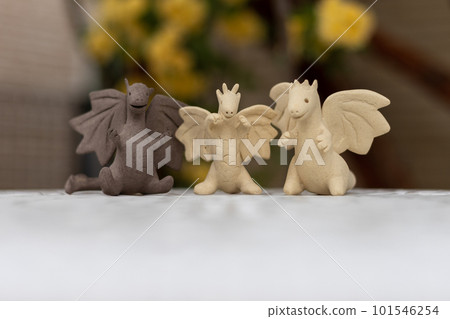 花園白桌上的三尊無釉龍俑 101546254