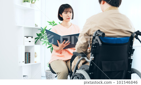 A nurse doctor who examines a man in a wheelchair A nurse doctor who examines a man in a wheelchair 101546846
