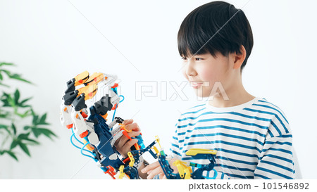A boy looking at the robot hand with a smile A boy looking at the robot hand with a smile 101546892