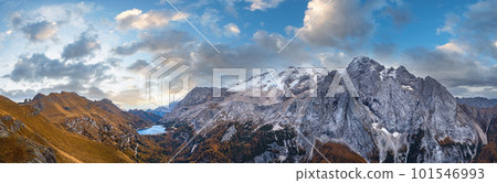 Autumn Dolomites mountain scene from hiking path betwen Pordoi Pass and Fedaia Lake, Italy. Snowy Marmolada Glacier and Fedaia Lake in far. 101546993