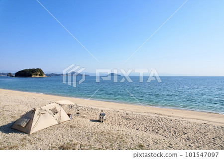 帶玩具貴賓犬的女子營地 蔚藍大海和美麗海灘上悠閒的海島營地 享受營地美食的女士 101547097
