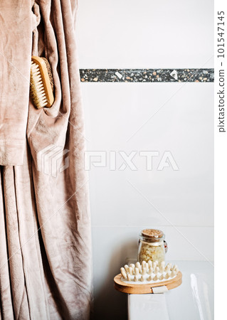 Wooden tray with home spa supplies and bathrobe in modern home bathroom for relaxing rituals. Spa decoration, natural organic products on a bathtube Wooden tray with home spa supplies and bathrobe in modern home bathroom for relaxing rituals. Spa decoration, natural organic products on a bathtube 101547145