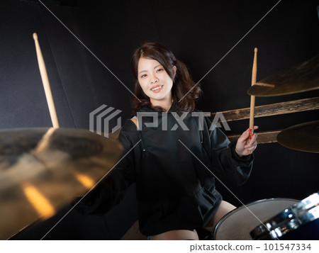 Woman playing drums with twin tails Woman playing drums with twin tails 101547334