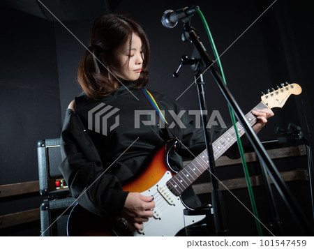 Woman playing guitar with twintails Woman playing guitar with twintails 101547459