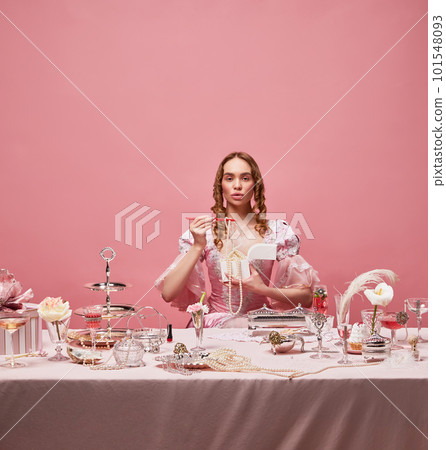 Shot of beautiful woman, princess wearing renaissance pink dress and standing with wine glass over studio background. Manners eating 101548093