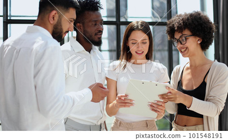 Employees working at computer together, discussing content 101548191