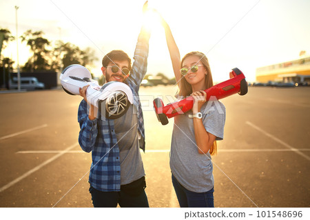 Young man and woman riding on the Hoverboard in the park. content technologies. a new movement. 101548696