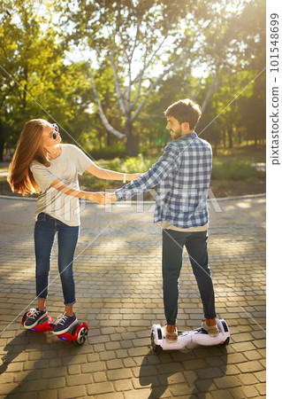Young man and woman riding on the Hoverboard in the park. content technologies. a new movement. 101548699