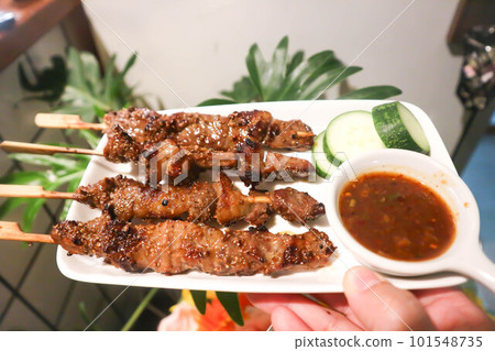barbecued beef or grilled beef , beef satay with sauce 101548735