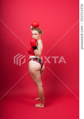 Seductive young and fit female fighter posing in gloves in studio Seductive young and fit female fighter posing in gloves in studio 101551456