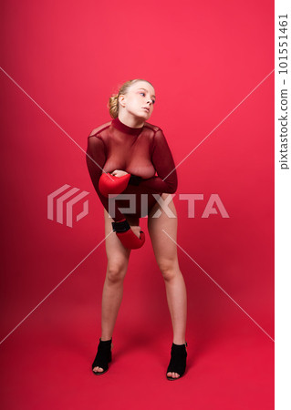 Seductive young and fit female fighter posing in gloves in studio 101551461