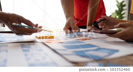 Close up ux developer and ui designer brainstorming about mobile app interface wireframe design at modern office. Creative digital development agency 101552460