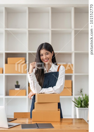 Young pretty asian start up business woman in apron working with online parcel box warehouse selling online product 101552770