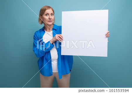 middle age business concept. middle-aged woman holding a poster for notes with a mocap on a blue middle age business concept. middle-aged woman holding a poster for notes with a mocap on a blue 101553594