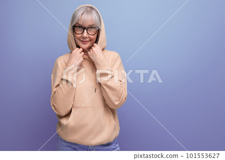 middle-aged woman in gray hair in a stylish jacket on a studio background with copy space 101553627