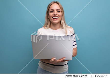 smiling funny young woman student with a laptop in her hands on a blue isolated background with copy smiling funny young woman student with a laptop in her hands on a blue isolated background with copy 101553633