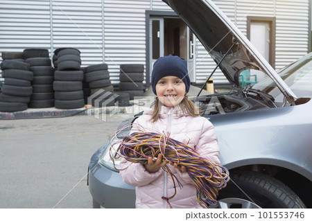 Little girl with wires on a background of a car. Car service Little girl with wires on a background of a car. Car service 101553746