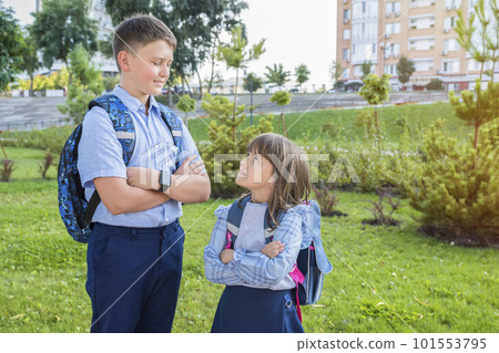 Elementary school students with backpacks outdoors in a park 101553795