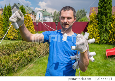 A man with an electric cable works in the garden. Backyard cleaning 101553841