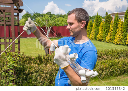A man works in the garden on a sunny day. Cleaning the area outdoors A man works in the garden on a sunny day. Cleaning the area outdoors 101553842