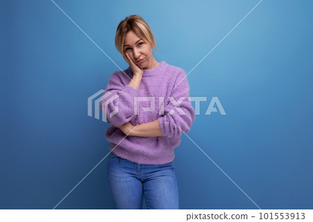 tired distressed blond young woman in purple hoodie on blue background with copy space 101553913