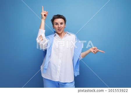 portrait of casual young brunette woman with short haircut in white shirt pointing finger portrait of casual young brunette woman with short haircut in white shirt pointing finger 101553922