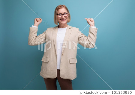 surprised adult woman with a bob hairstyle in a classic jacket points to the side on a bright surprised adult woman with a bob hairstyle in a classic jacket points to the side on a bright 101553950