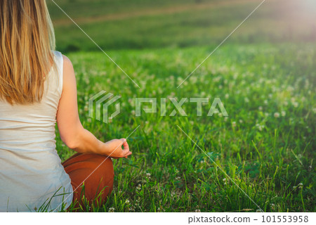 Woman doing yoga on the green grass at the mountain. Carpathians Woman doing yoga on the green grass at the mountain. Carpathians 101553958