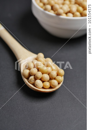 close up of Raw soy bean seed on spoon over black background close up of Raw soy bean seed on spoon over black background 101554575