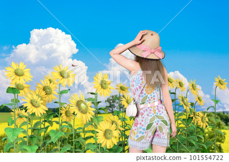 A girl in a straw hat who is impressed by the energetic sunflowers in midsummer 101554722