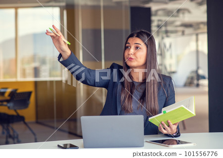 Photo of pretty young girl sit desktop pc hold pen write notepad shirt in home office indoors. Photo of pretty young girl sit desktop pc hold pen write notepad shirt in home office indoors. 101556776