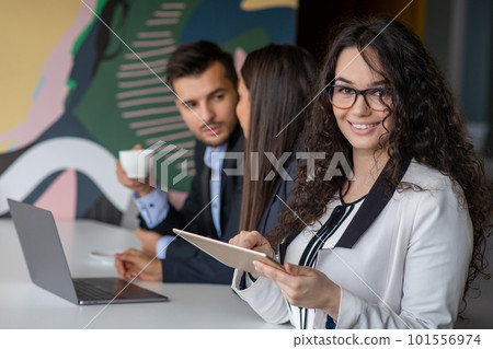 Business team collaborating on project together, using laptops. Business colleagues in casual working together in contemporary office space. 101556974