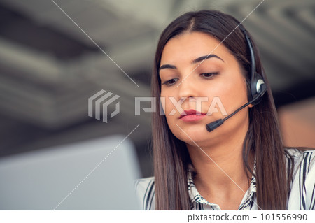 Young friendly operator woman agent with headsets working in a call centre. 101556990