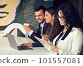 Business team collaborating on project together, using laptops. Business colleagues in casual working together in contemporary office space. 101557081