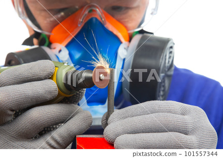 Male locksmith worker processes metal with engraving drill cutting. 101557344