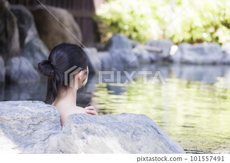 一位年輕女子在露天浴池中放鬆的背影 101557491