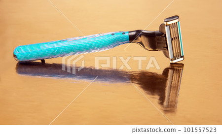 razor cassette on golden background. manual face shaving machine. stubble blade. depilation razor cassette on golden background. manual face shaving machine. stubble blade. depilation 101557523