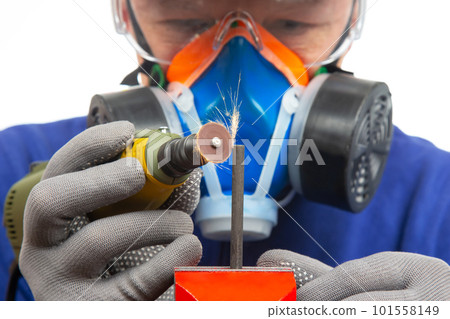 Male locksmith worker processes metal with engraving drill cutting.  101558149