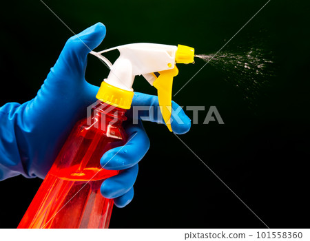 water sprayer bottle in a hand with gloves water sprayer bottle in a hand with gloves 101558360