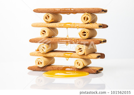 Fresh flower honey flows and drips onto herdry crispy cookie sticks. Dessert snack food. Fresh flower honey flows and drips onto herdry crispy cookie sticks. Dessert snack food. 101562035