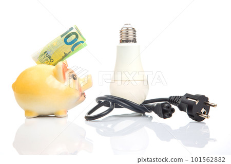 Piggy bank, LED lamp and electric cable plug. Saving electricity. Energy saving concept Piggy bank, LED lamp and electric cable plug. Saving electricity. Energy saving concept 101562882